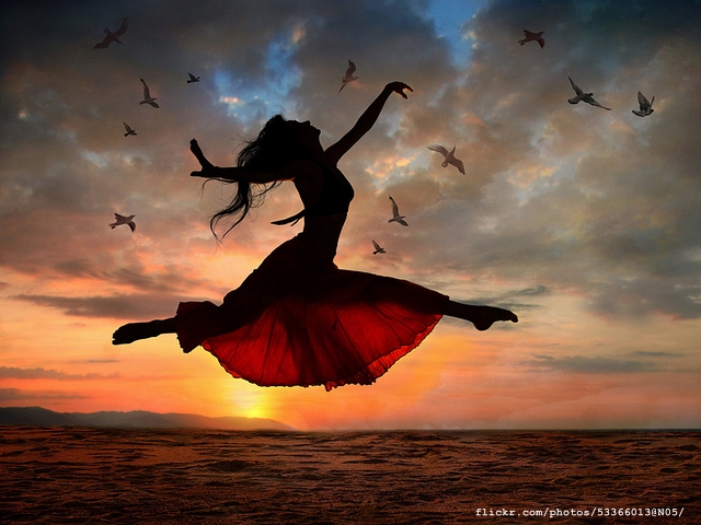Jumping woman at sunset